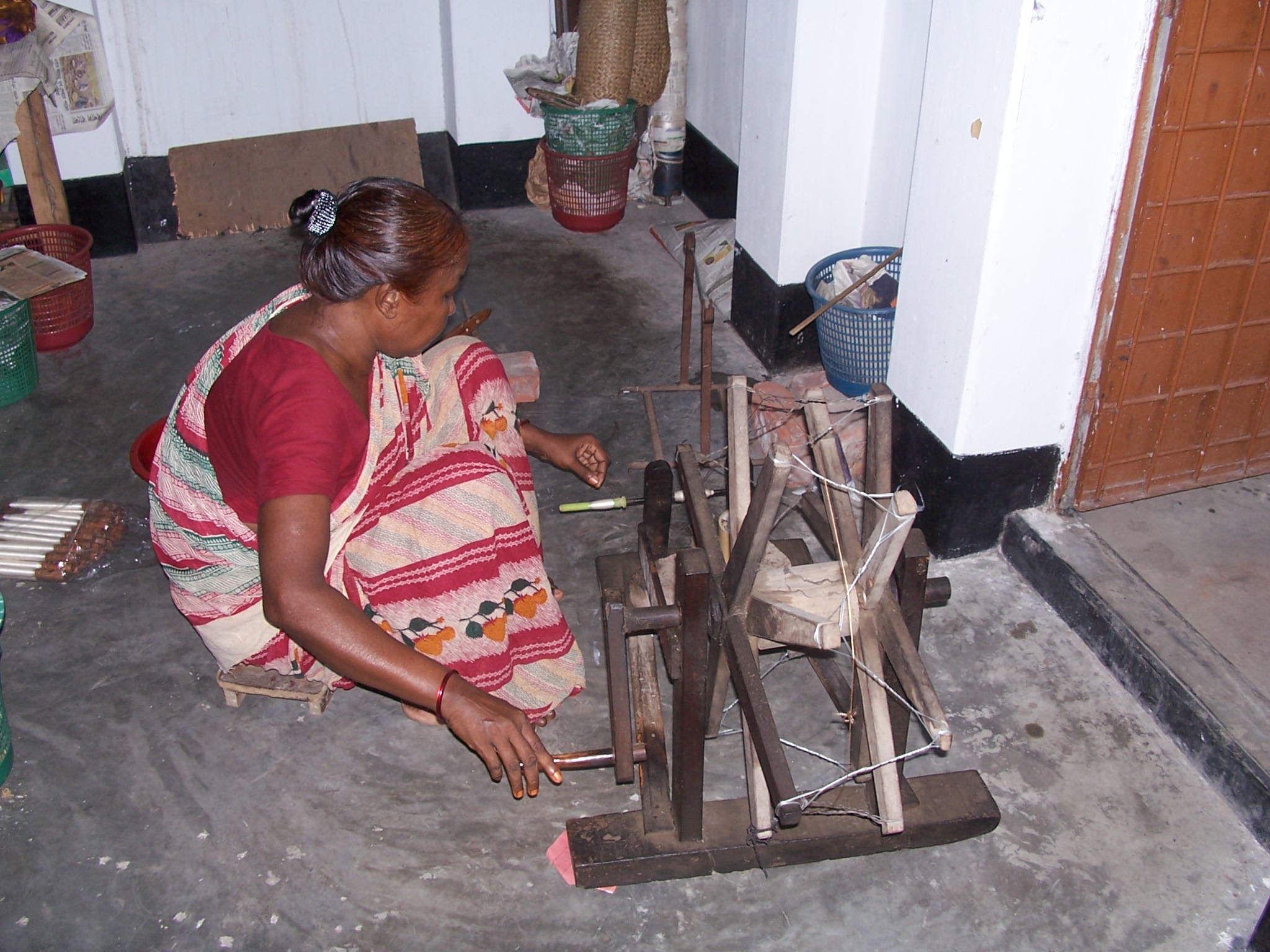A woman working a silk loom 