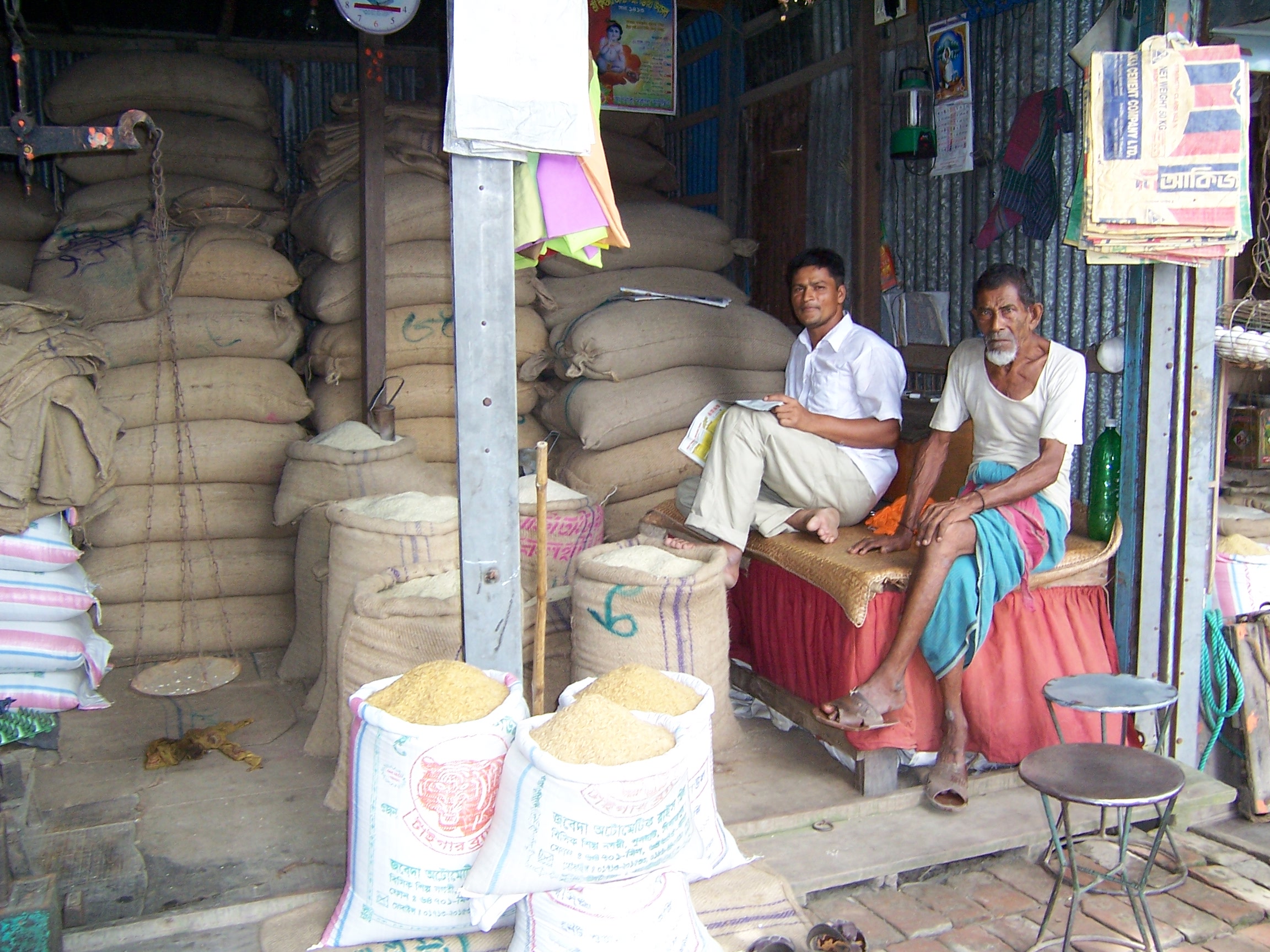 Two men selling grain at their shop 