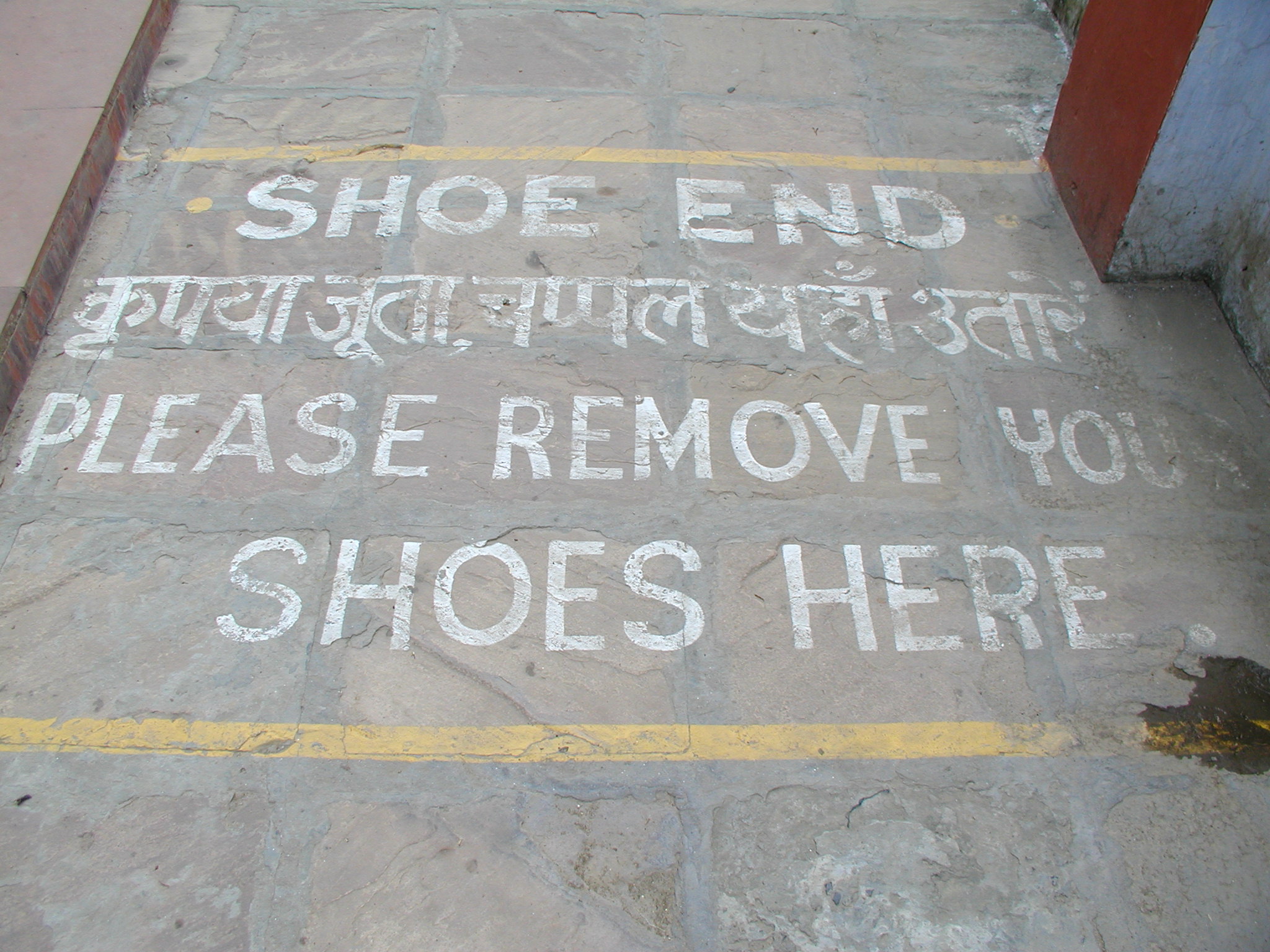 A sign asking visitors to remove their shoes before entering a Buddhist temple 