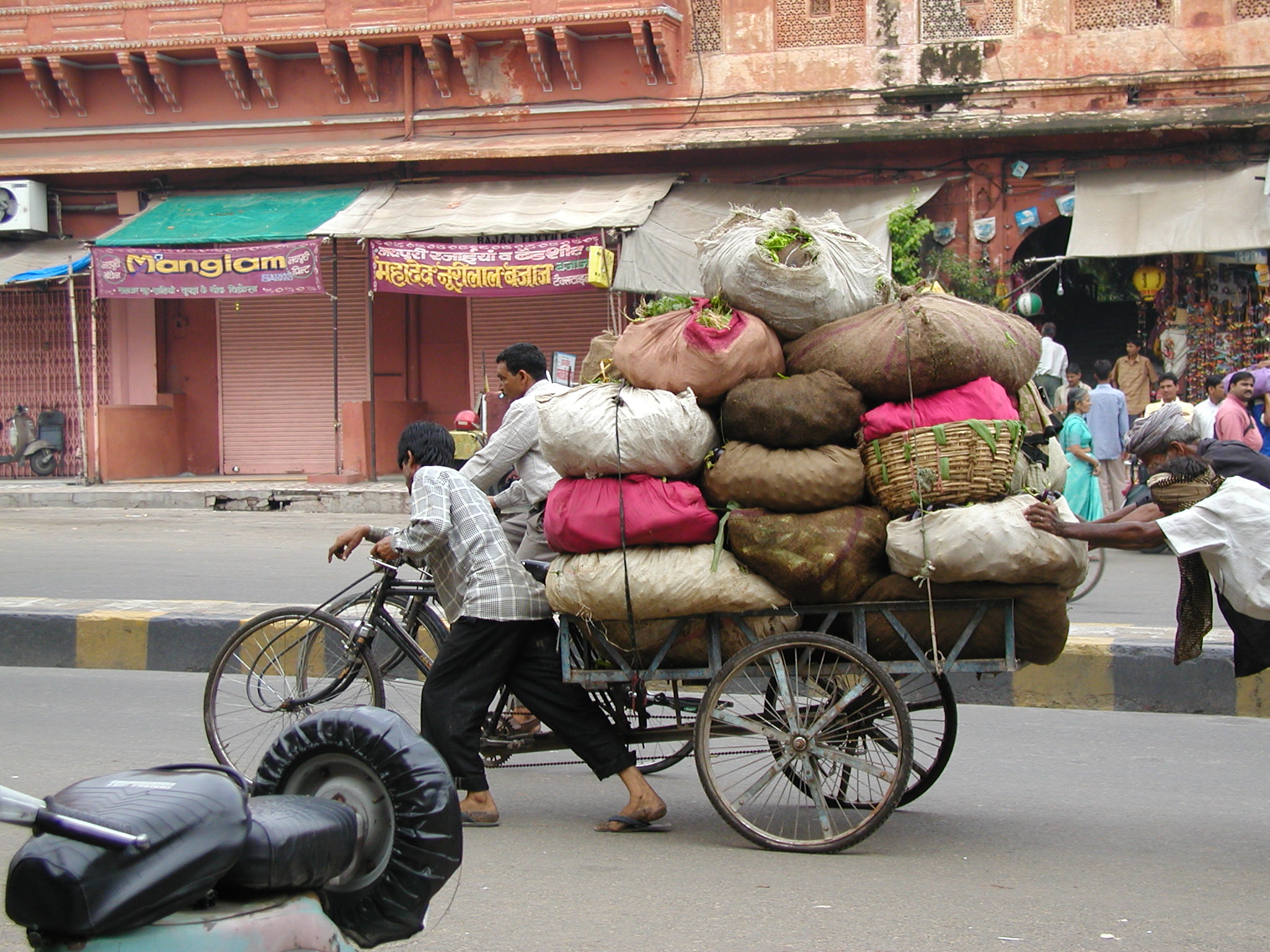 A man carrying his goods on a cart 