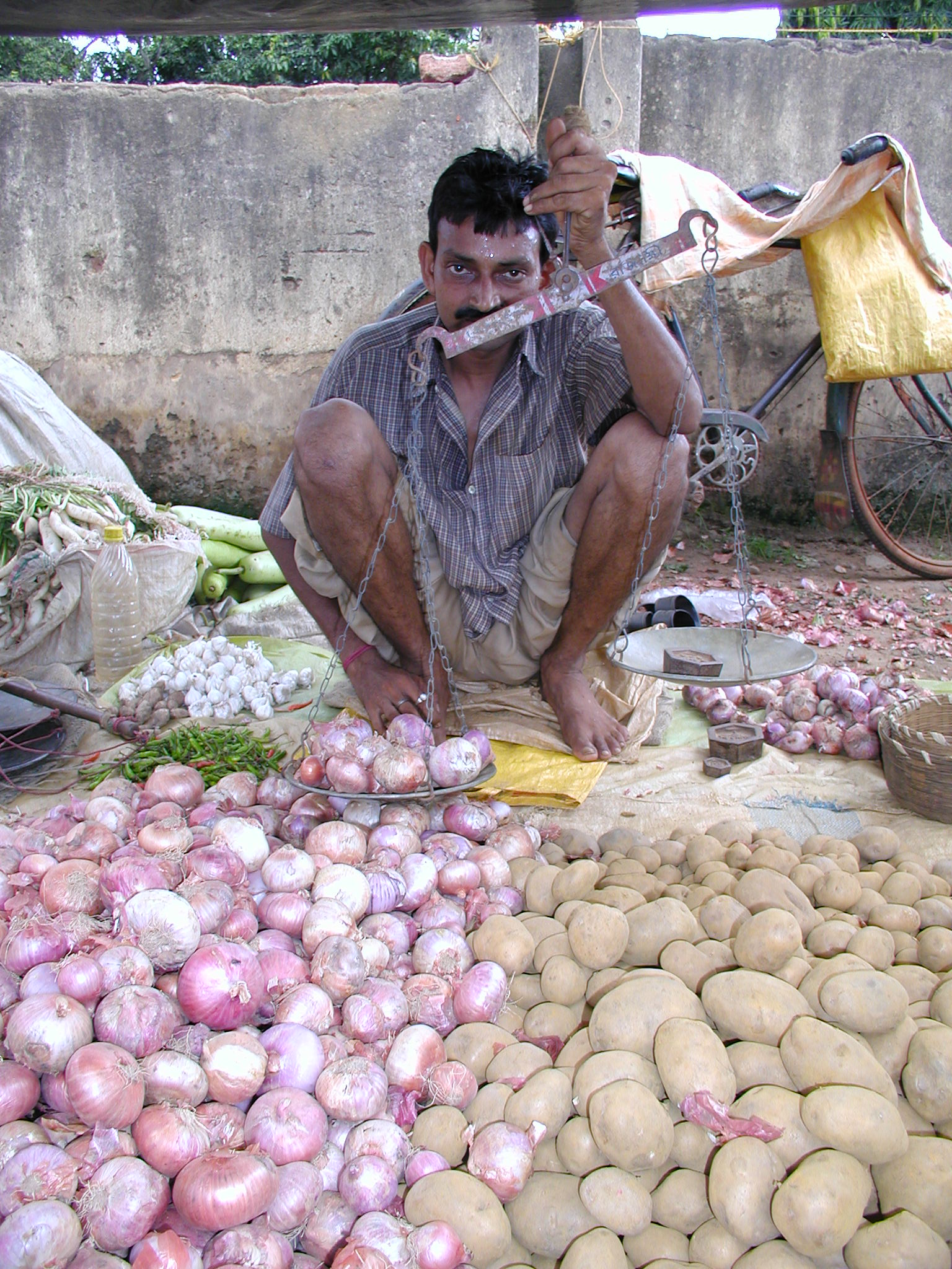 A man sells his vegetables at the market in Dumka 