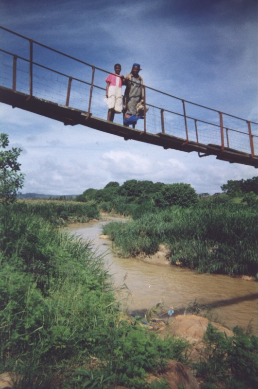 Two women on a foot bridge over a river