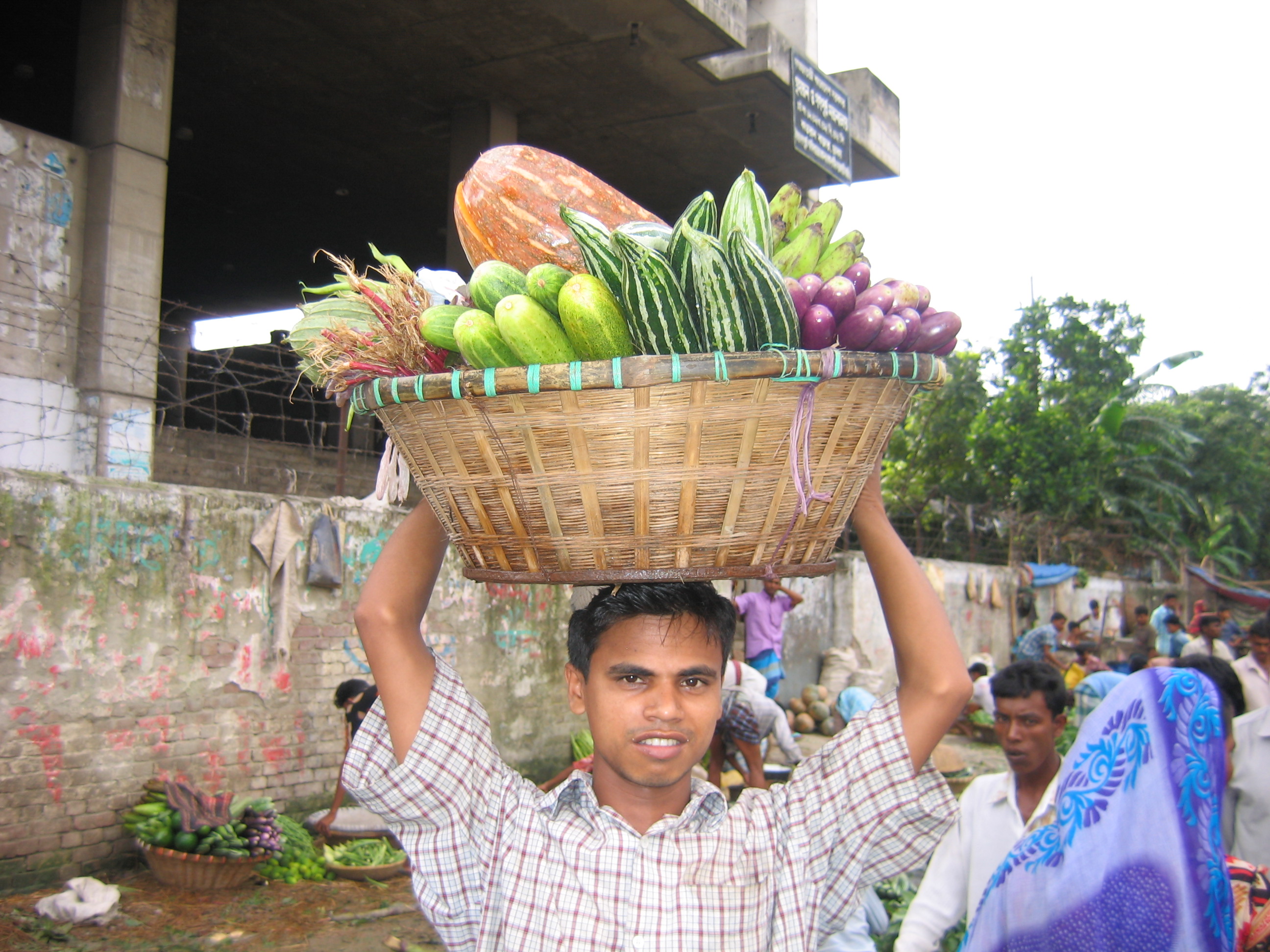A man carrying a basket of vegetables on his head 