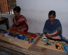 Two women work in a silk shop.