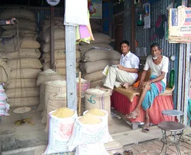 Two men sell grain in their shop.