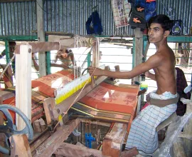 A boy working a silk loom.