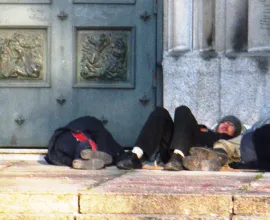 Homeless men sleep on the front steps of a church in Santiago.