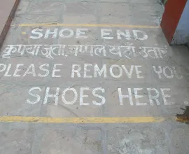 A sign telling visitors to take their shoes off before entering a Buddhist temple.