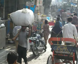 The streets of Delhi, full of carts, pedestrians, goods, and shops.