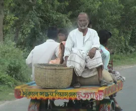 A family travels down the road on the back of a trailer.