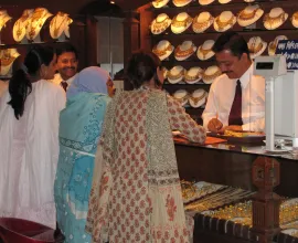 Three women shop for jewelry at a store.