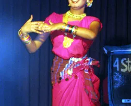 A women dances in fancy traditional dress.