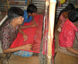 Working on silk by hand in a factory.