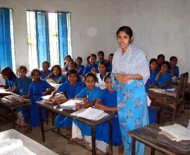 A teacher and her class in a elementary classroom.