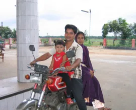 A family of three fits onto a motorcycle.