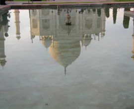 The Taj Mahal reflects into a pool.