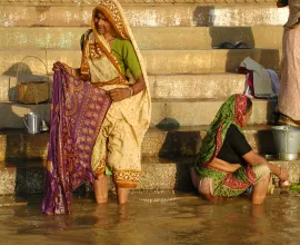 Women do laundry along the shore in Varanasi.